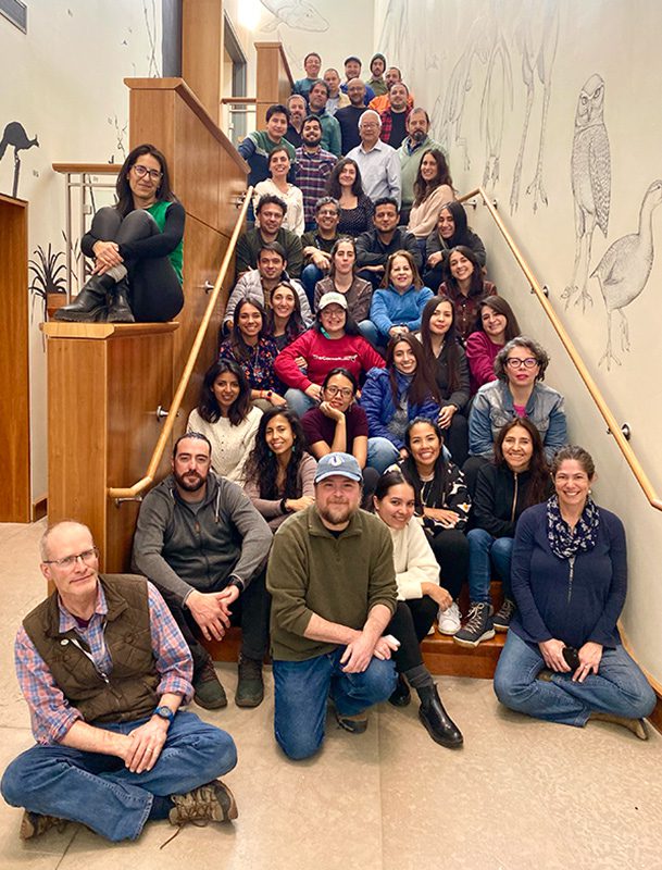 Approximately 40 people sitting and standing on a staircase at the Cornell Lab of Ornithology.